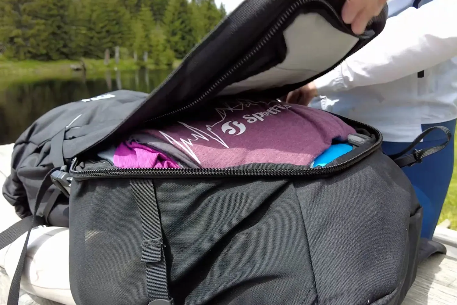 Geöffneter Frontzugang des BACH Shield Plus 35 mit Kleidung im Hauptfach