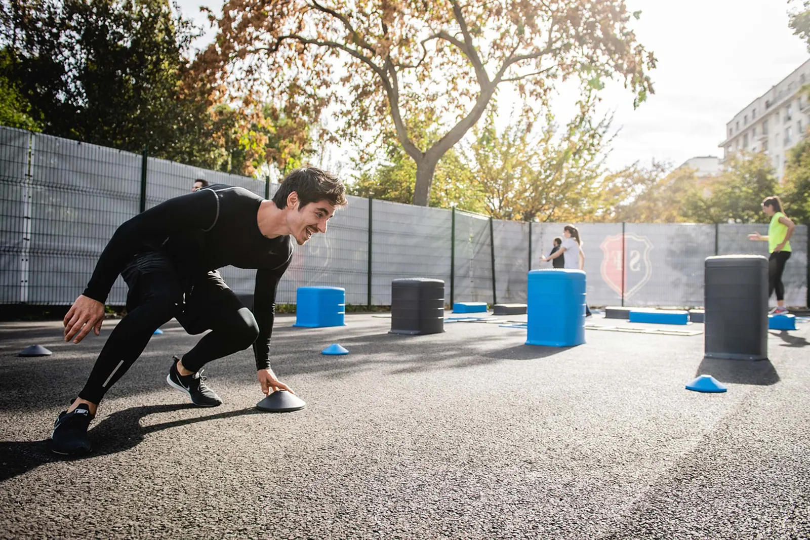Mann beim Training auf einer festen Fläche in einem Outdoor-Fitnessbereich
