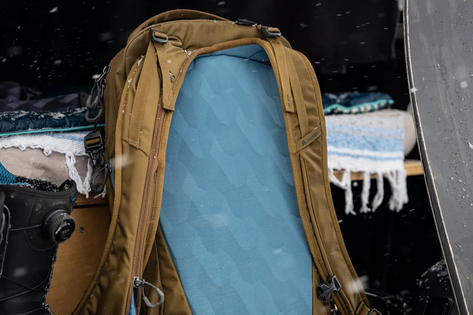 Geformtes blaues Rückenpolster eines braunen Gregory-Rucksacks im Schnee