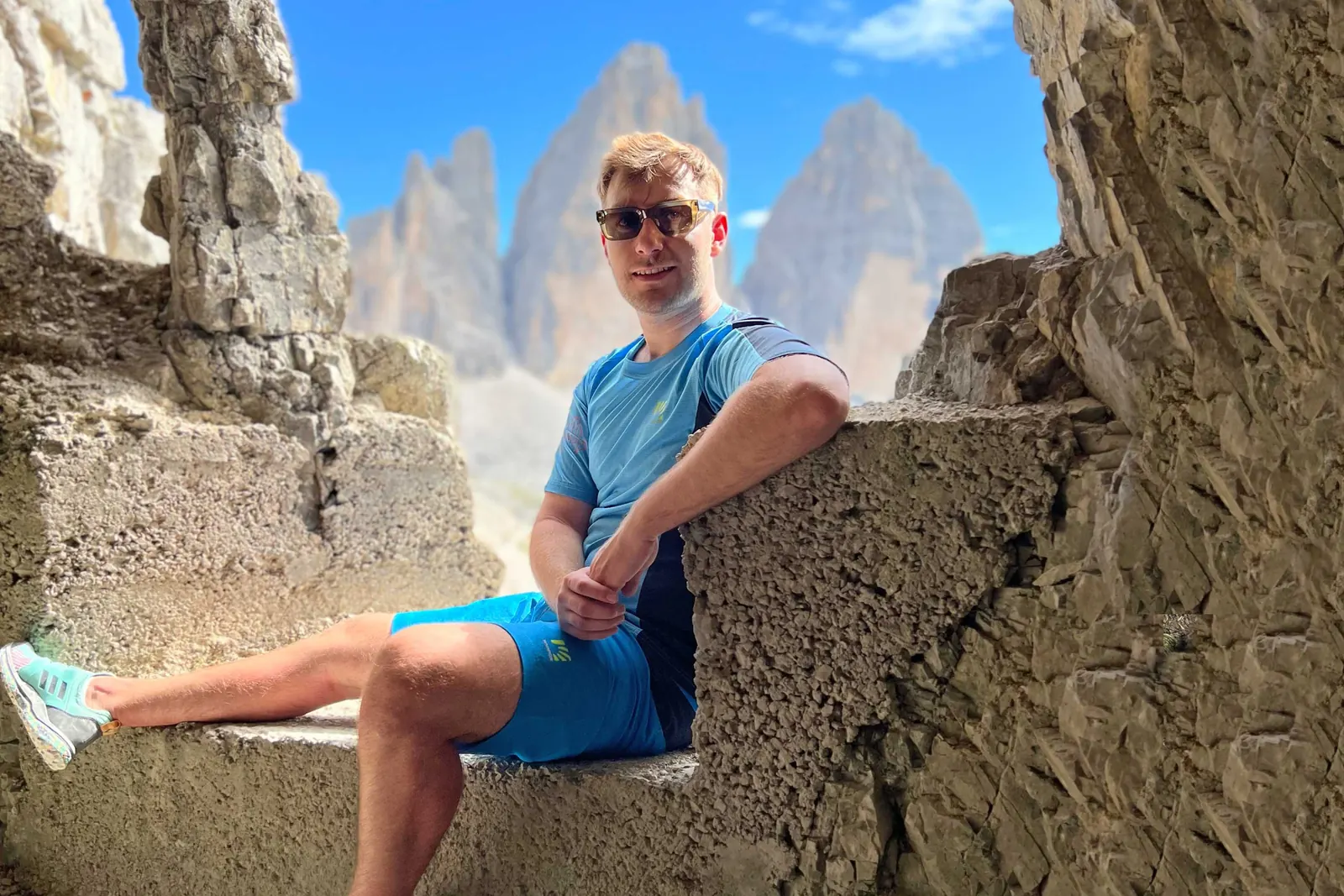 Nico in blauem Karpos-Shirt und Shorts vor den Drei Zinnen