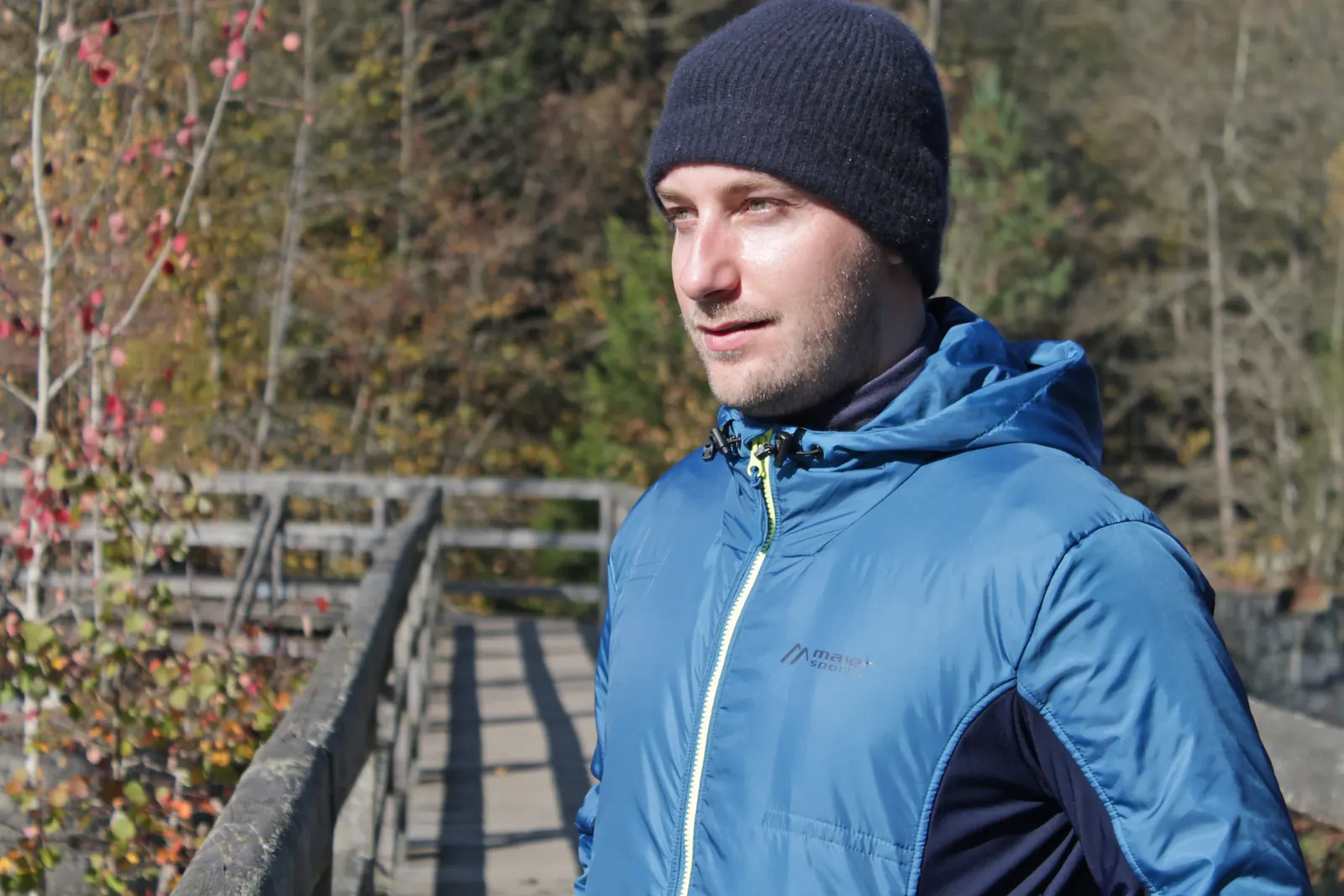 Nicolas trägt die blaue Caurus Wool mit Kapuze und dunklen seitlichen Einsätzen