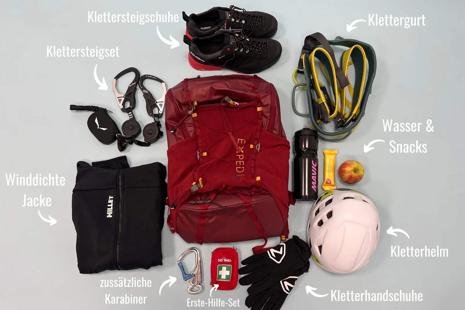 Ausgelegte Klettersteigausrüstung mit Rucksack, Gurt, Helm, Schuhen, Handschuhen und Verpflegung