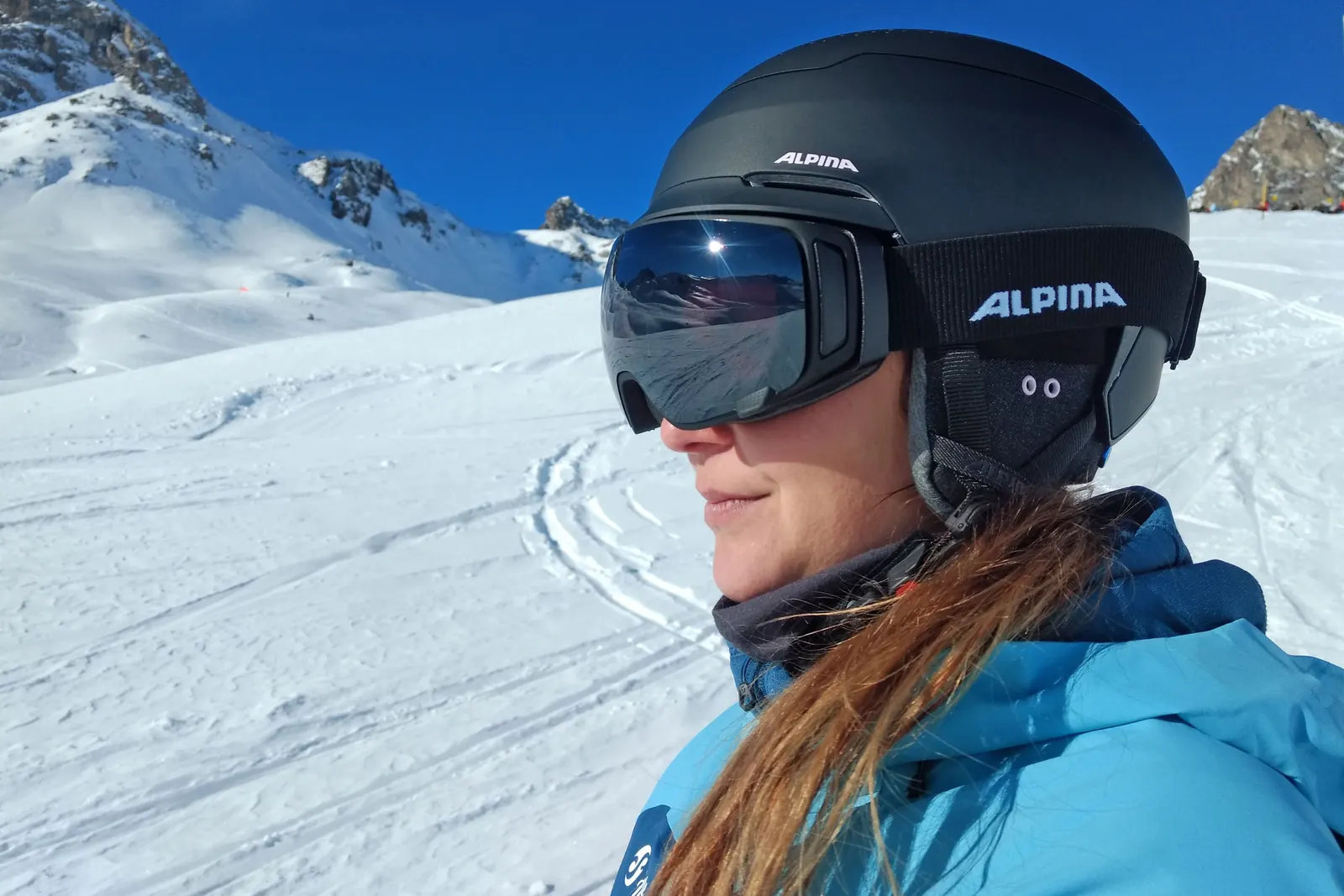 Katrin trägt den ALPINA Gems mit der separaten Skibrille Double Jack MAG Q im Schnee