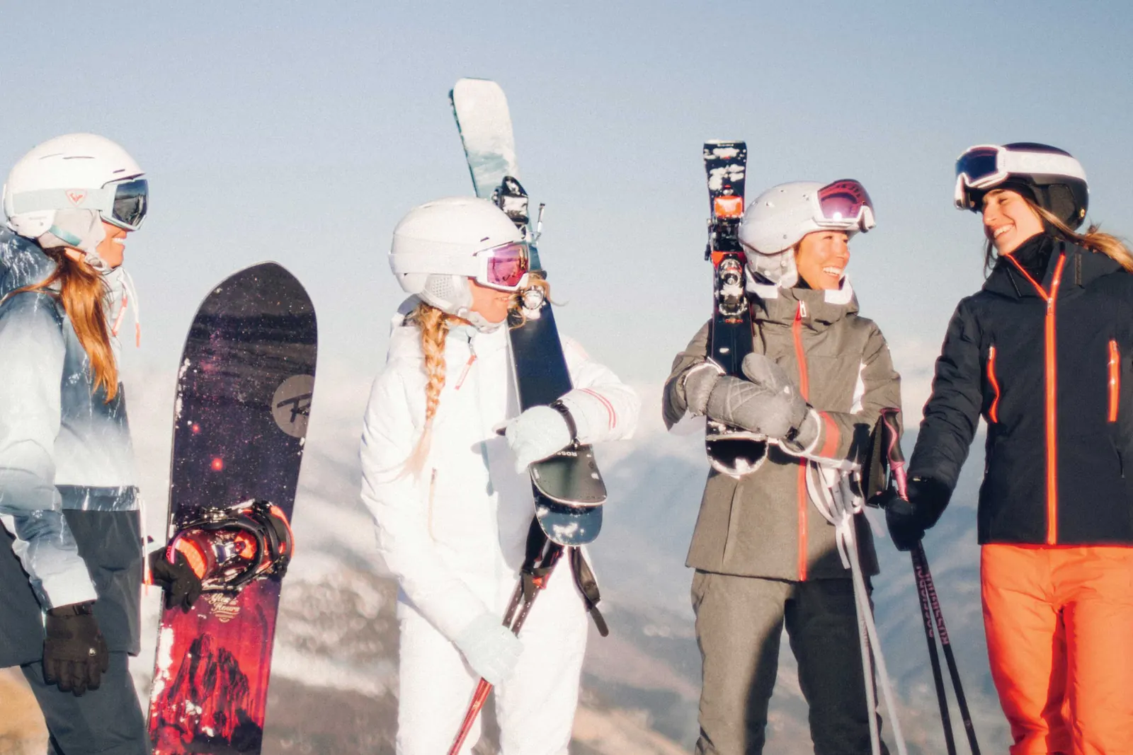 Vier Wintersportler mit Ski und Snowboards in unterschiedlich geschnittener Rossignol-Bekleidung