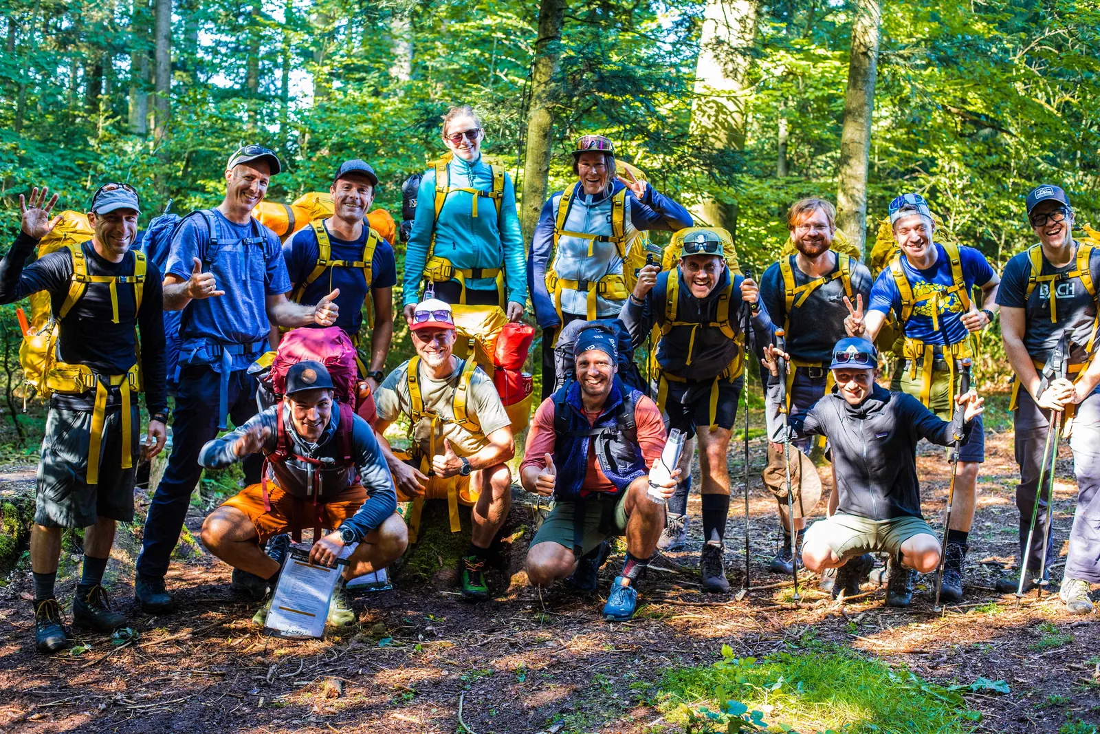 Gruppe der BACH WildernessNight 2021 mit Rucksäcken auf einem Weg im Wald