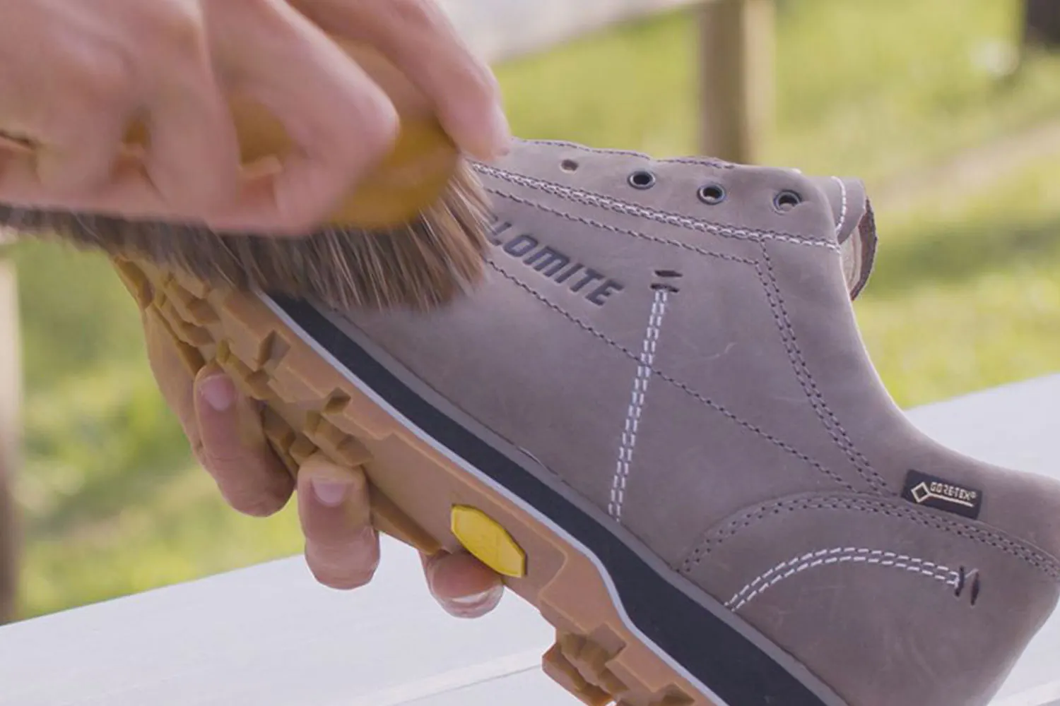 Eine weiche Bürste reinigt einen lilafarbenen Dolomite-Lederschuh