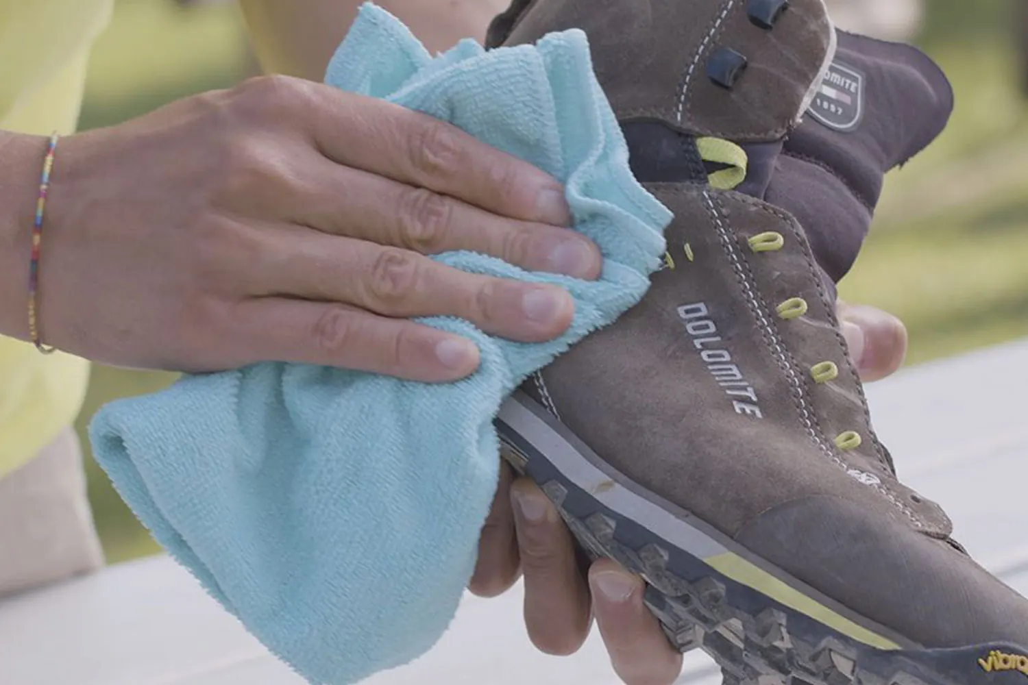 Ein Dolomite-Schuh aus Rauleder wird mit einem blauen Tuch abgewischt