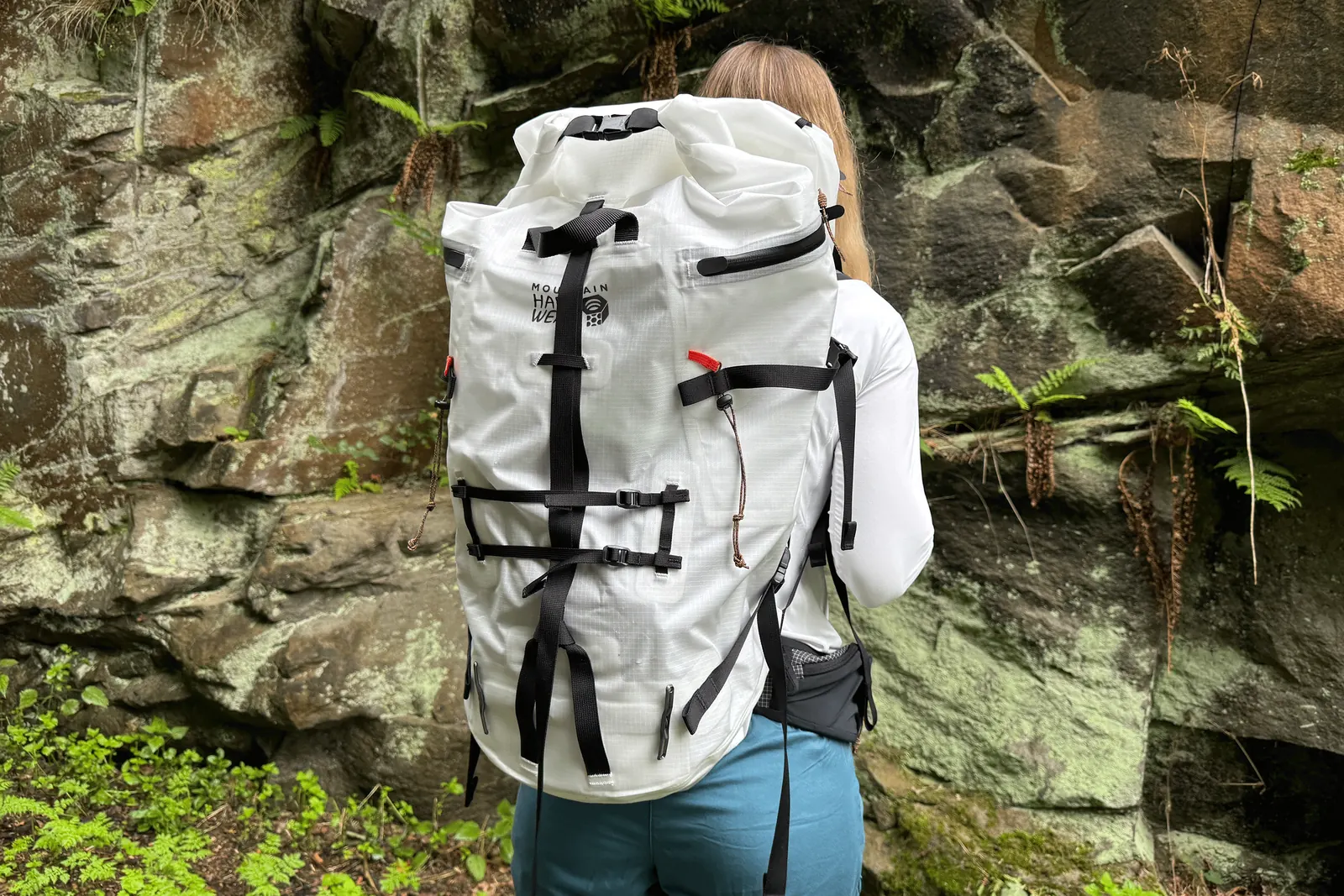 Heller Alpine Light Roll Top am Rücken einer Person vor einer Felswand