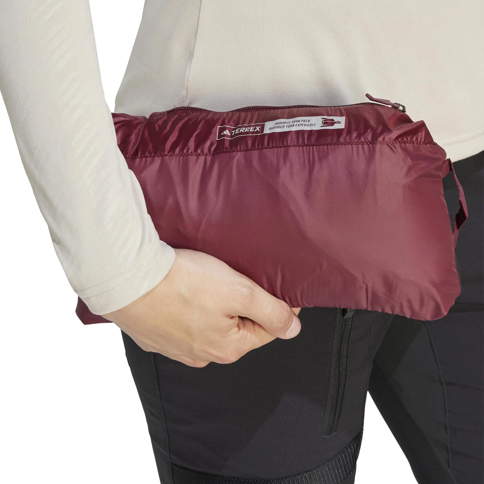 Eine Person hält eine in ihrer Tasche verstaute rote adidas-TERREX-Jacke