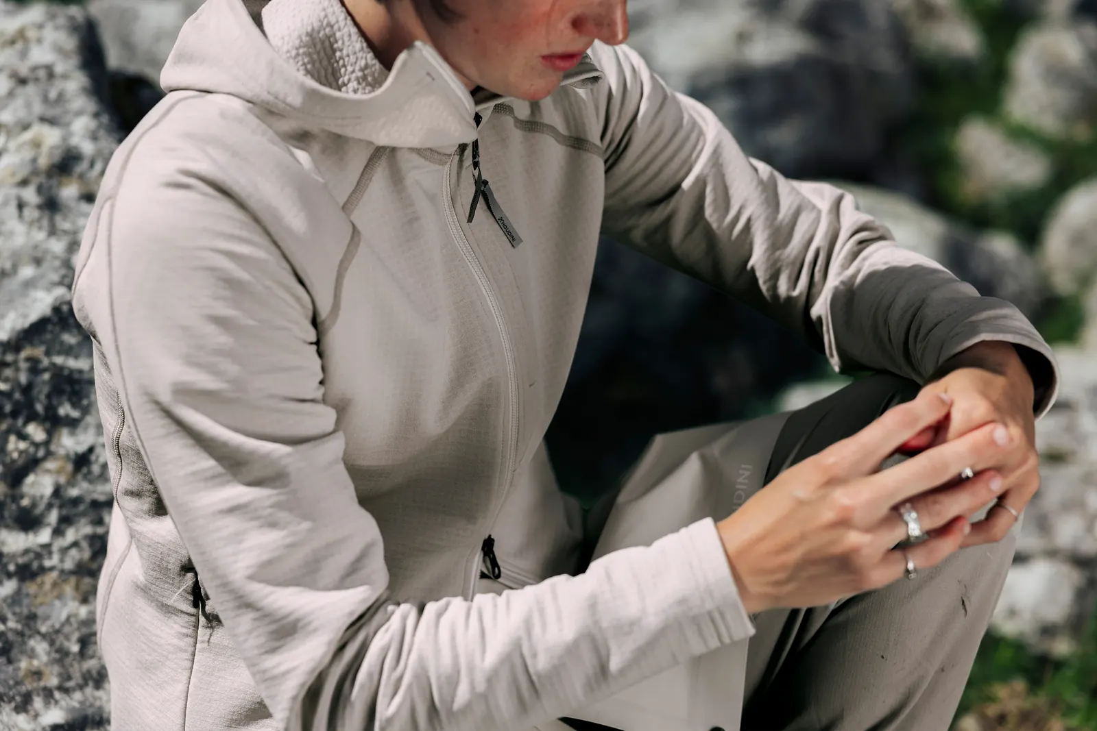 Detail einer hellen Houdini-Kapuzenjacke mit Brusttasche und strukturierter Stoffinnenseite