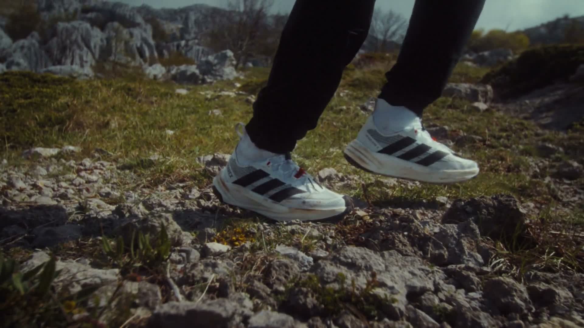adidas Terrex Freehiker 3 Ultra mit hohem Strickschaft beim Gehen über felsigen Untergrund