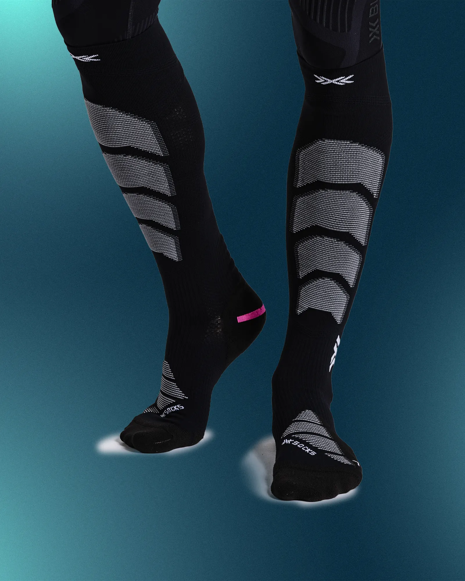 Beine in schwarzen X-Socks Ski Anatomix Skisocken mit grauen Polsterzonen