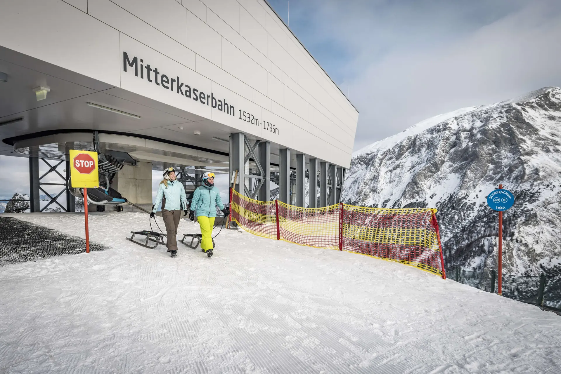 Zwei Rodler mit Schlitten an der Talstation der Mitterkaserbahn am Jenner