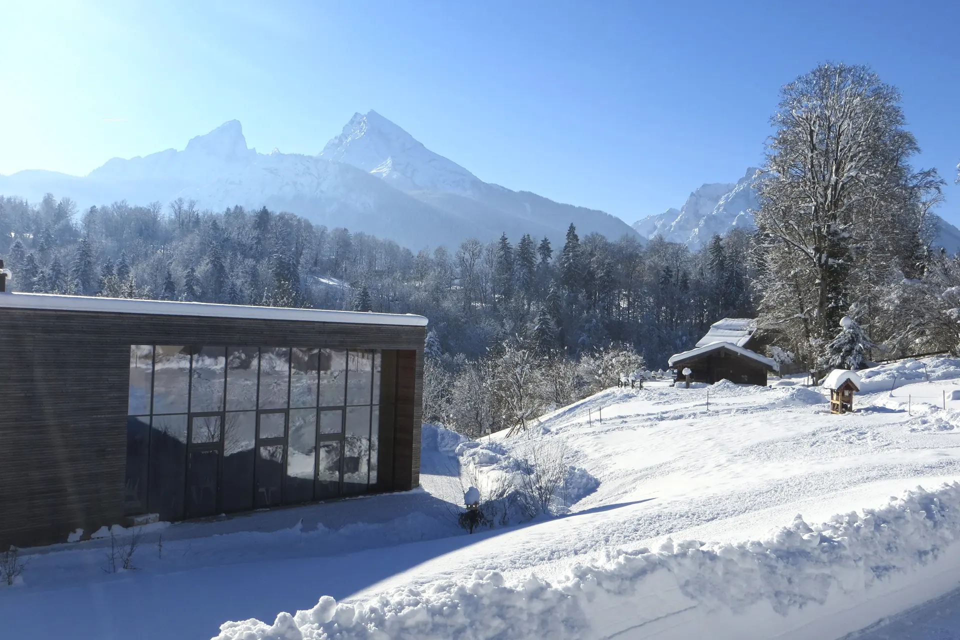 Verschneiter Watzmann über dem Nationalparkzentrum Haus der Berge in Berchtesgaden