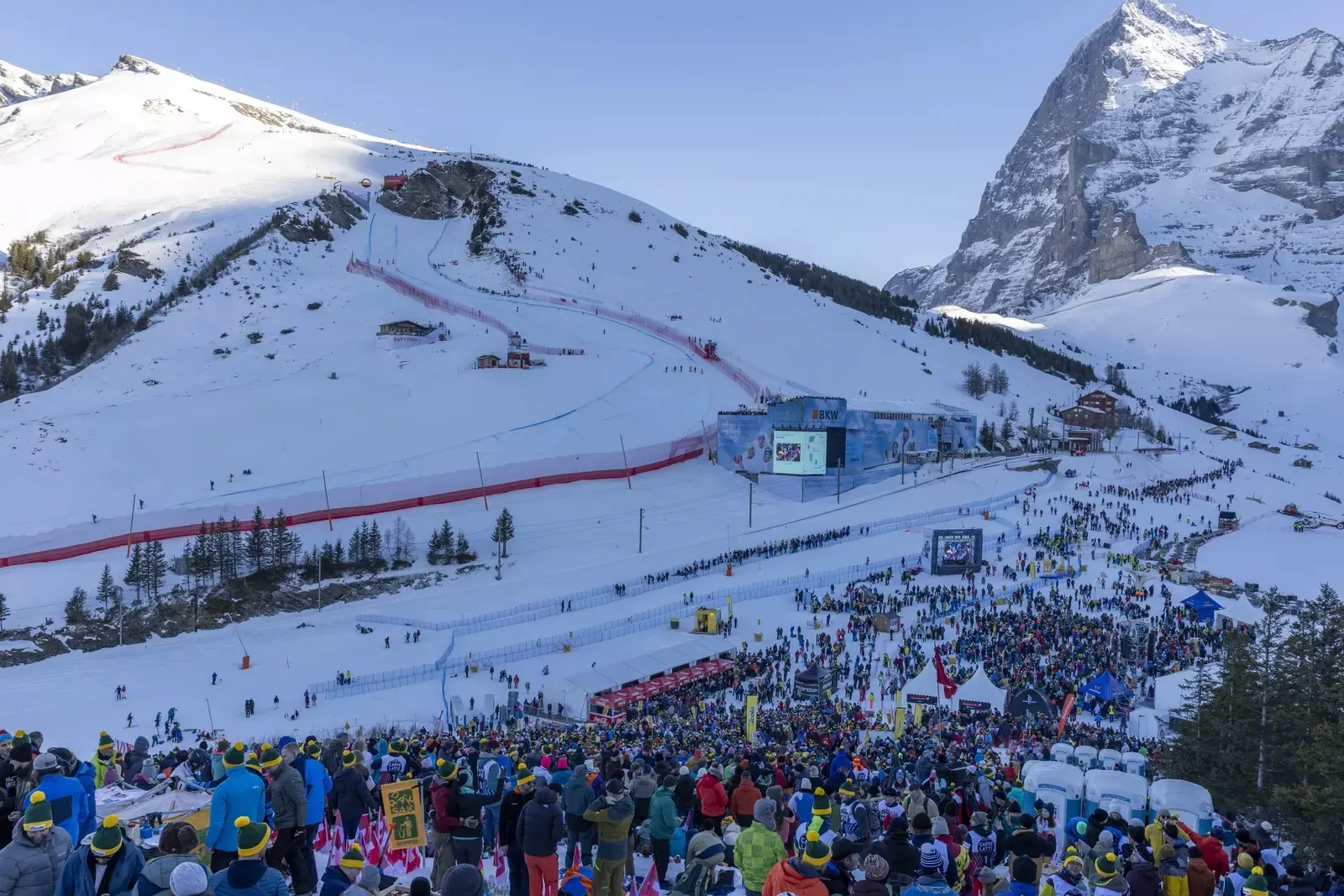 Publikum im Zielraum der Lauberhornrennen in Wengen, dahinter die Rennstrecke am Hang und die Eiger-Nordwand