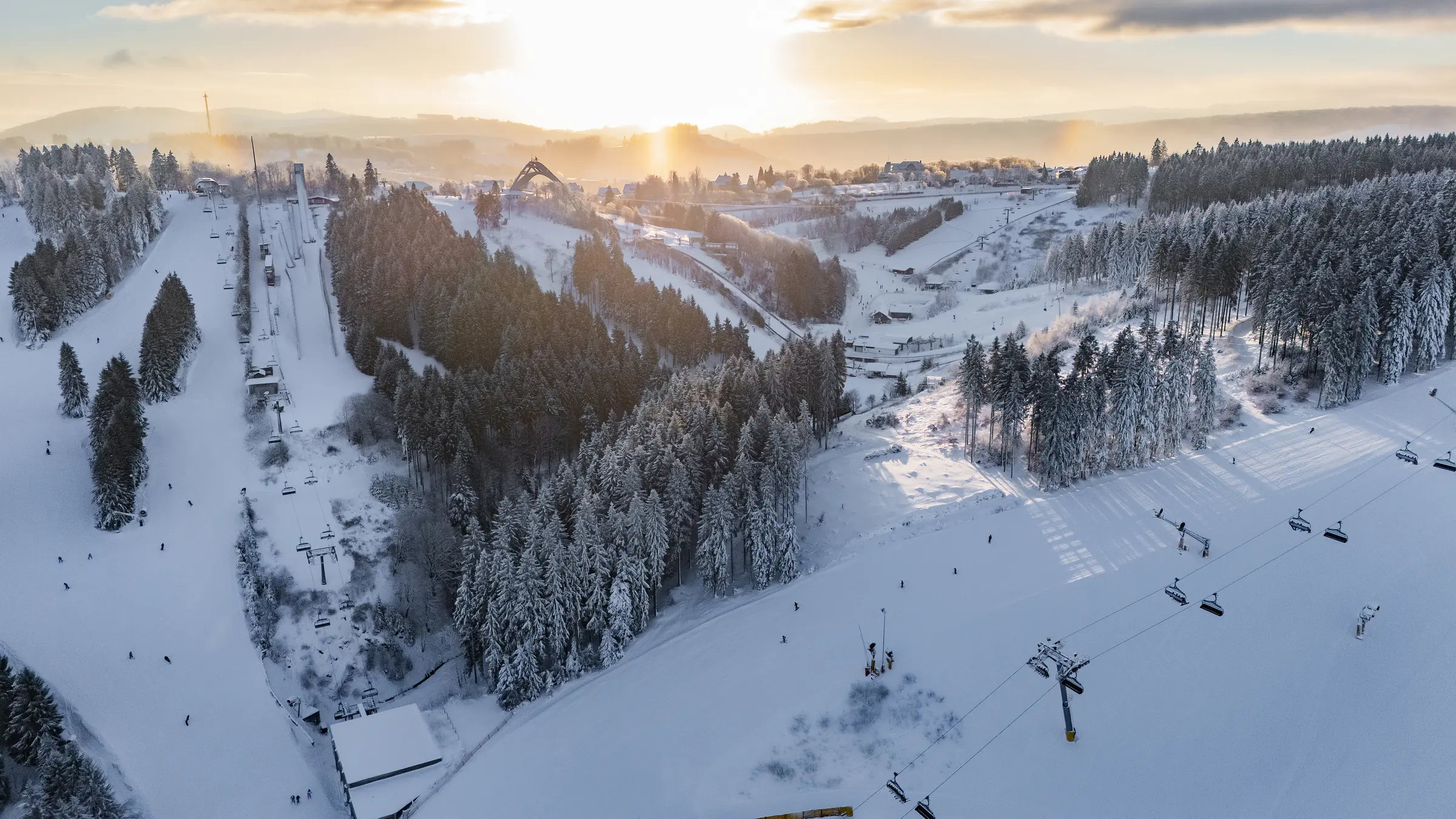 Winter in Winterberg: Skiliftkarussell Winterberg bei Sonnenaufgang, verschneite Pisten und Wald