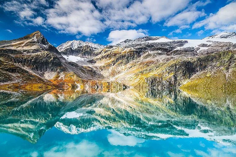 Der Weißsee an der Bergstation, im Wasser spiegeln sich die Gipfel und Gletscher