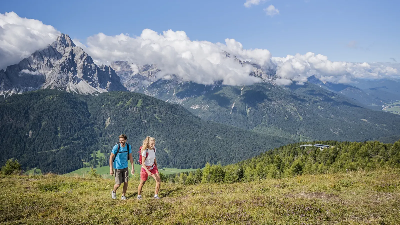 Wanderer auf einer Almwiese am Helm vor den Sextner Dolomiten