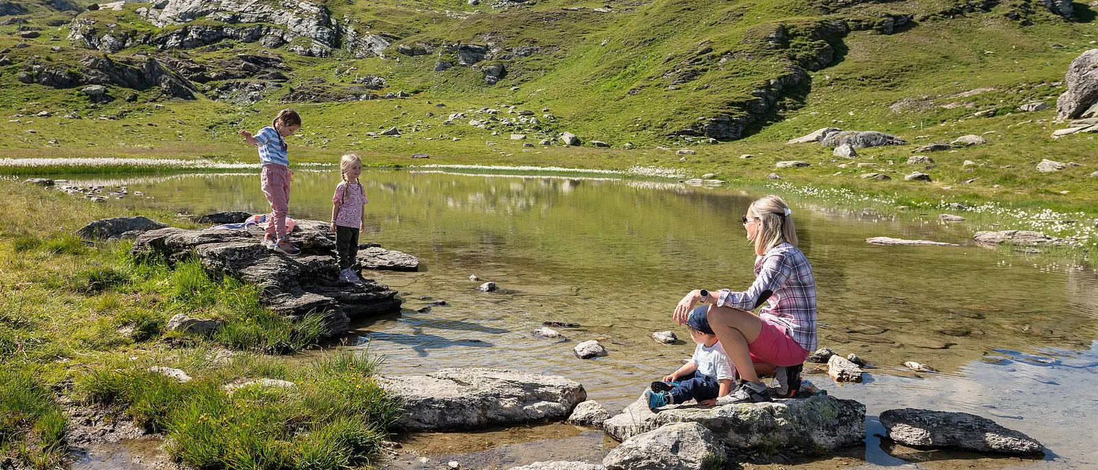 Familie an einem Bergsee auf dem Wasserweg Furtschellas