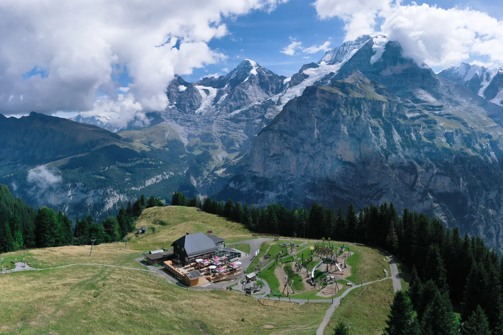 Allmendhubel mit Wiesen und Bergrestaurant vor Eiger, Mönch und Jungfrau