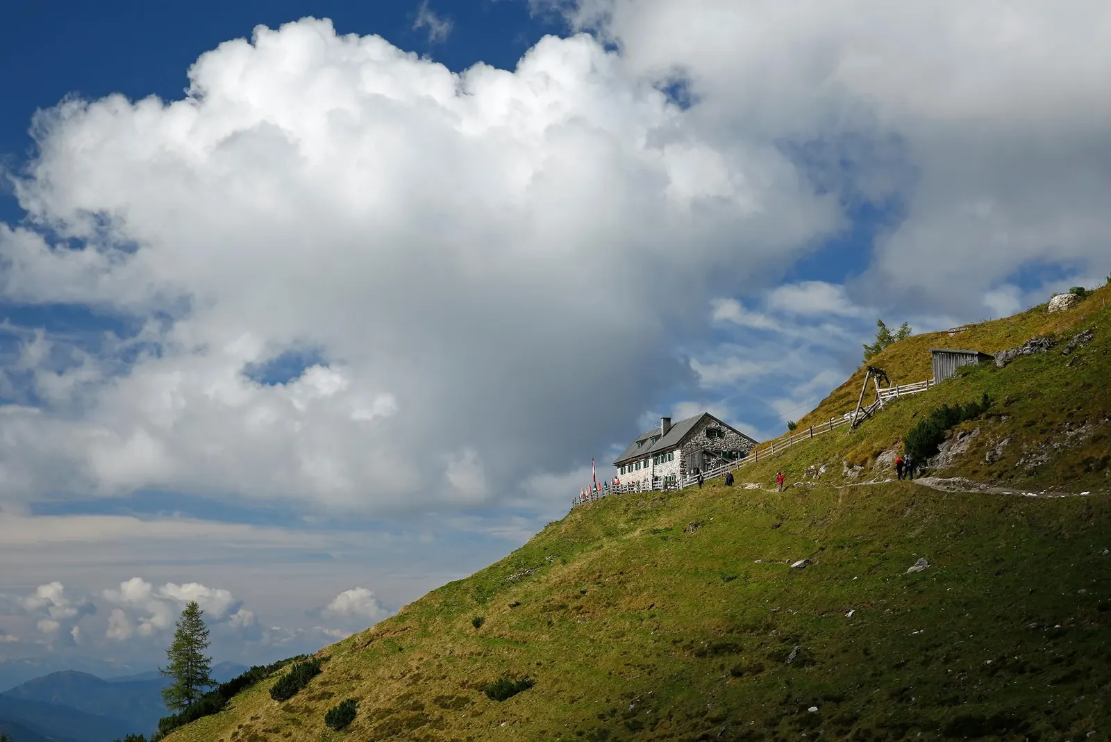 Südwandhütte auf grünen Hängen im Dachsteingebirge
