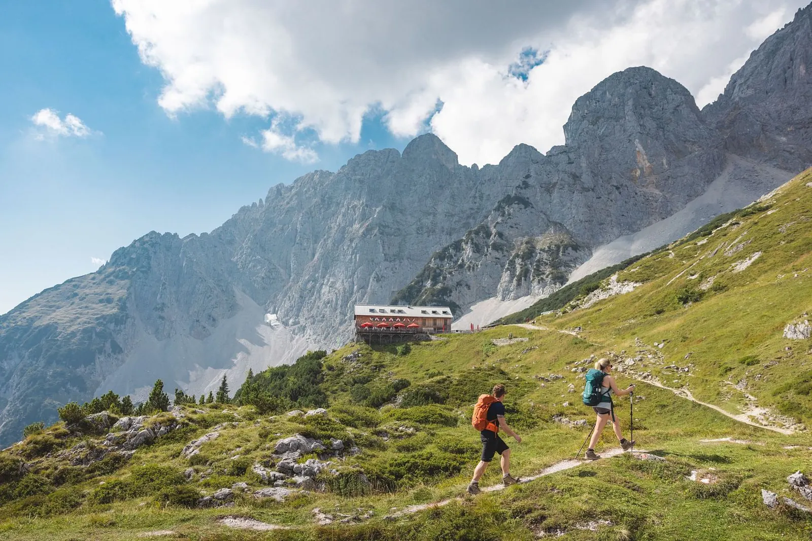 Wandernde auf dem Weg zur Gruttenhütte unter den Kalkwänden des Wilden Kaisers