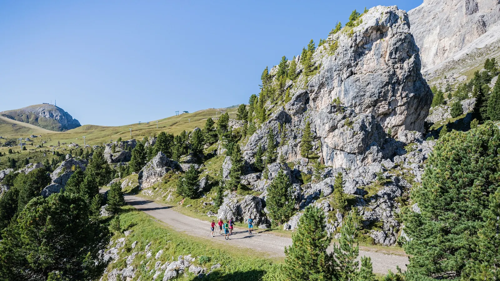 Wandernde zwischen Felsblöcken in der Steinernen Stadt am Langkofel