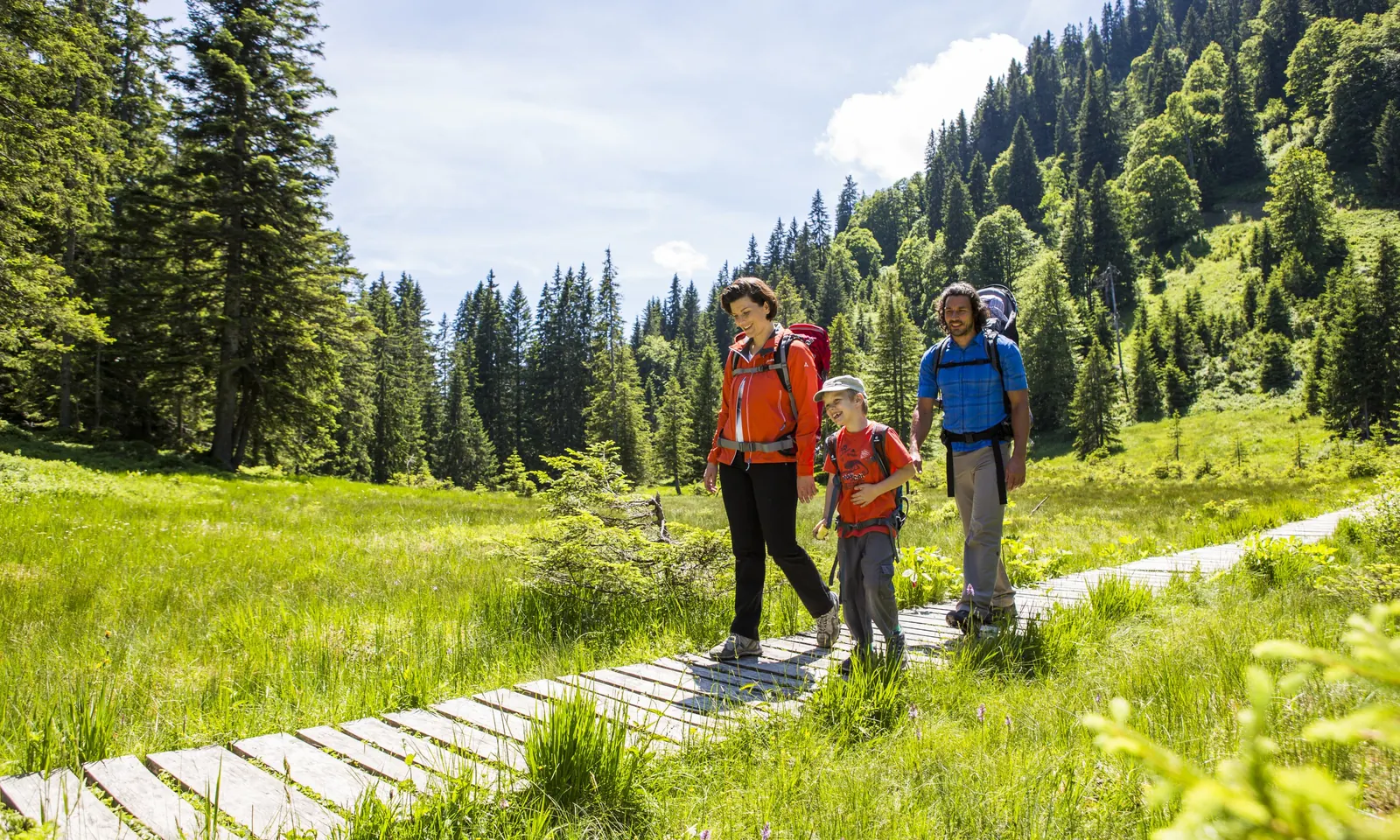 Familie auf dem Holzsteg durch das Hühnermoosmoor am Söllereck