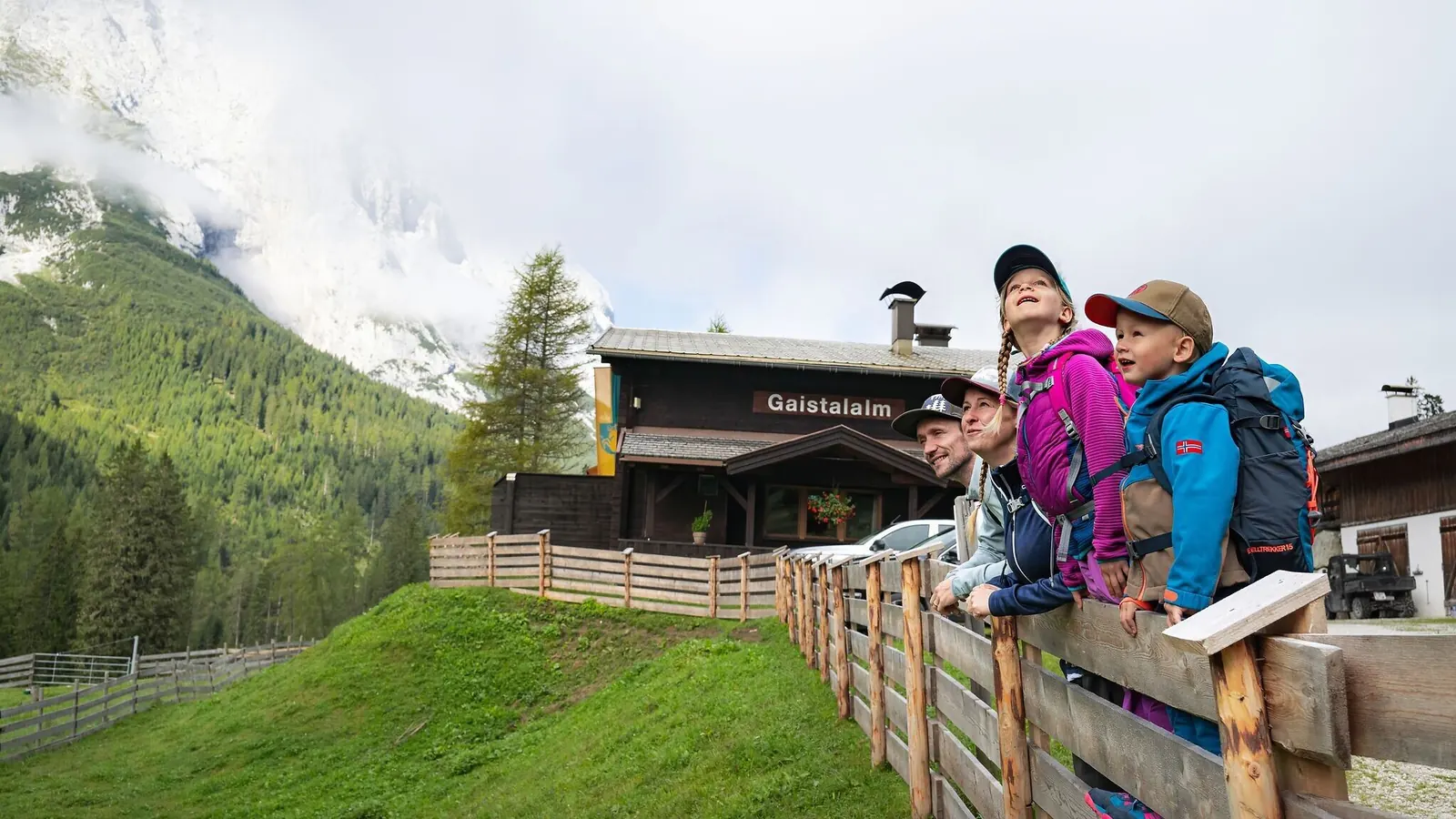 Familie mit Rucksäcken vor der Gaistalalm