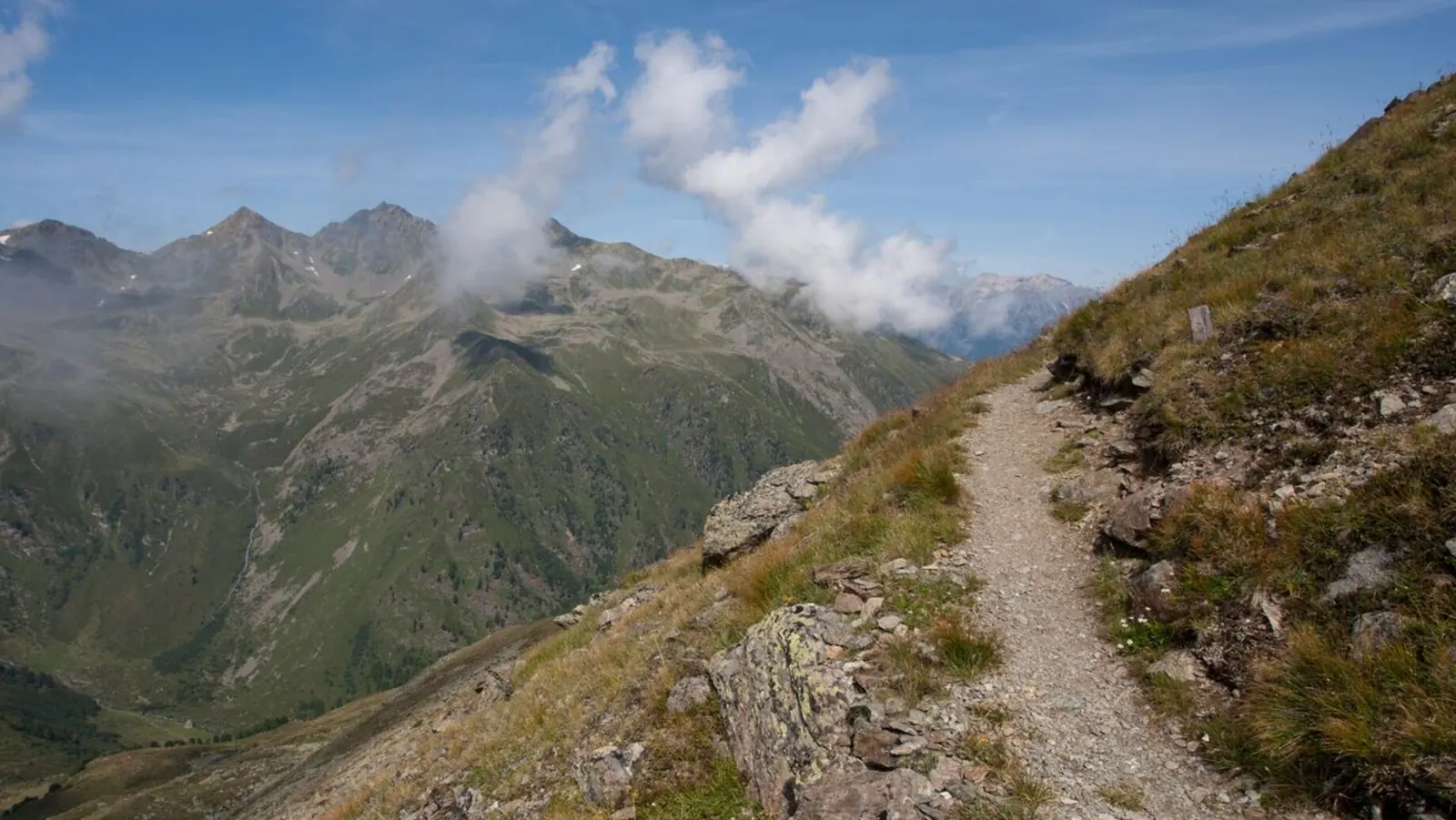 Wanderpfad vom Schönjoch zum Zwölferkopf über grünen und felsigen Hängen