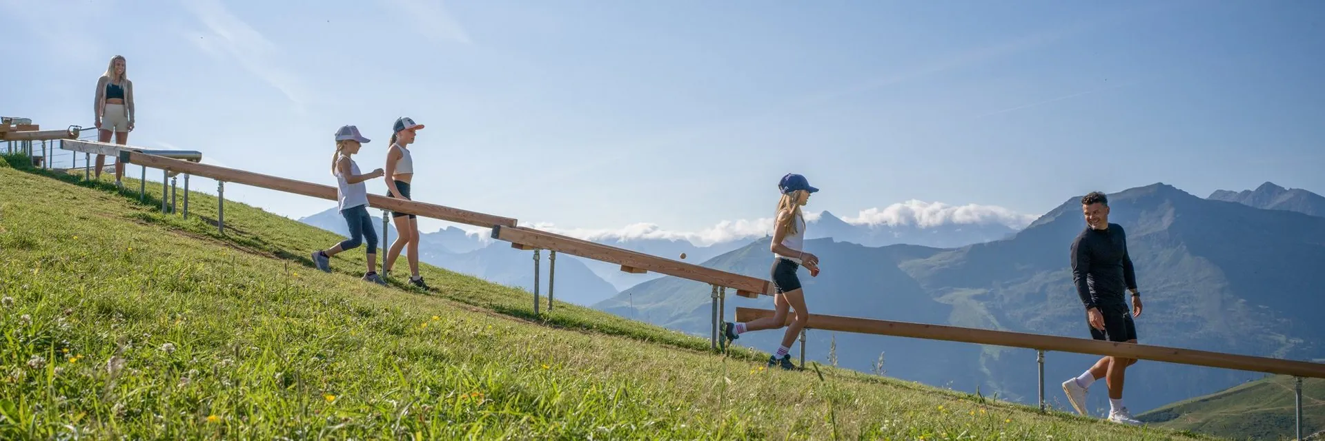 Familie an einer hölzernen Kugelbahn auf der Schlossalm