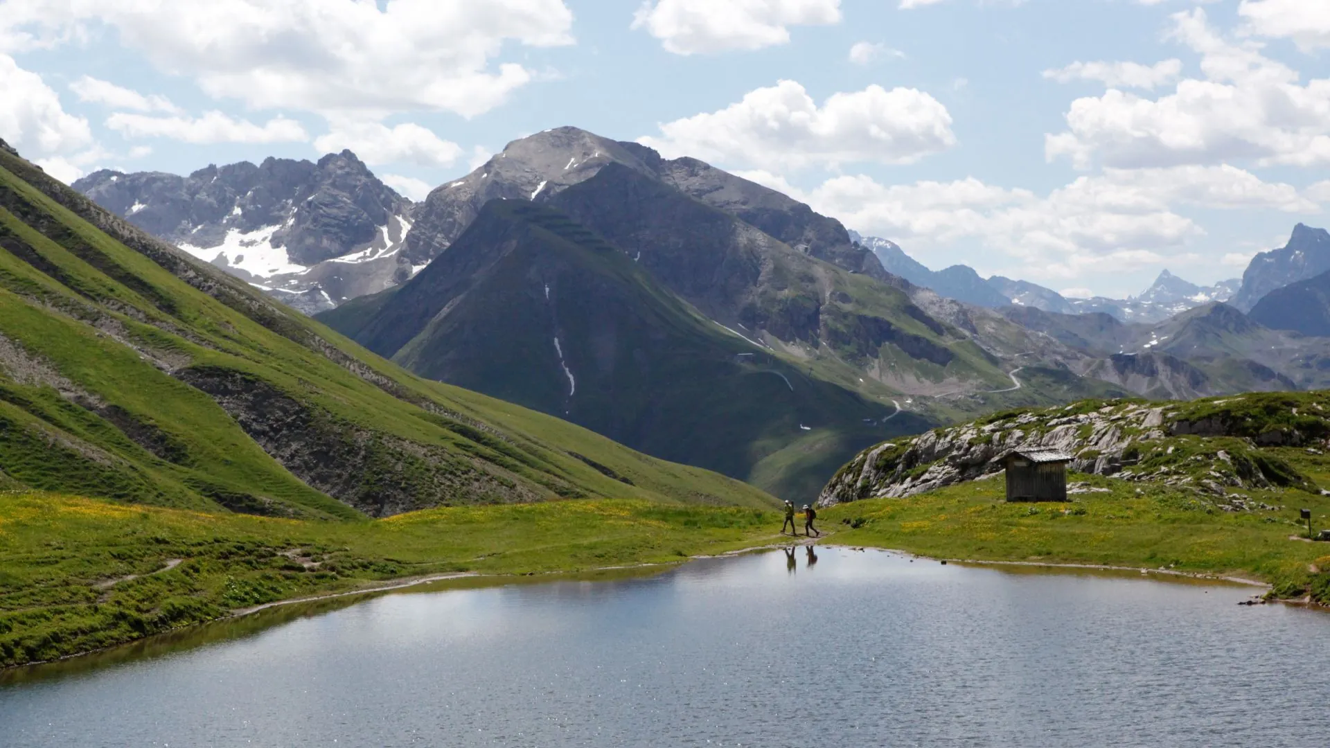 Monzabonsee zwischen grünen Berghängen und hellen Kalkfelsen am Rüfikopf.