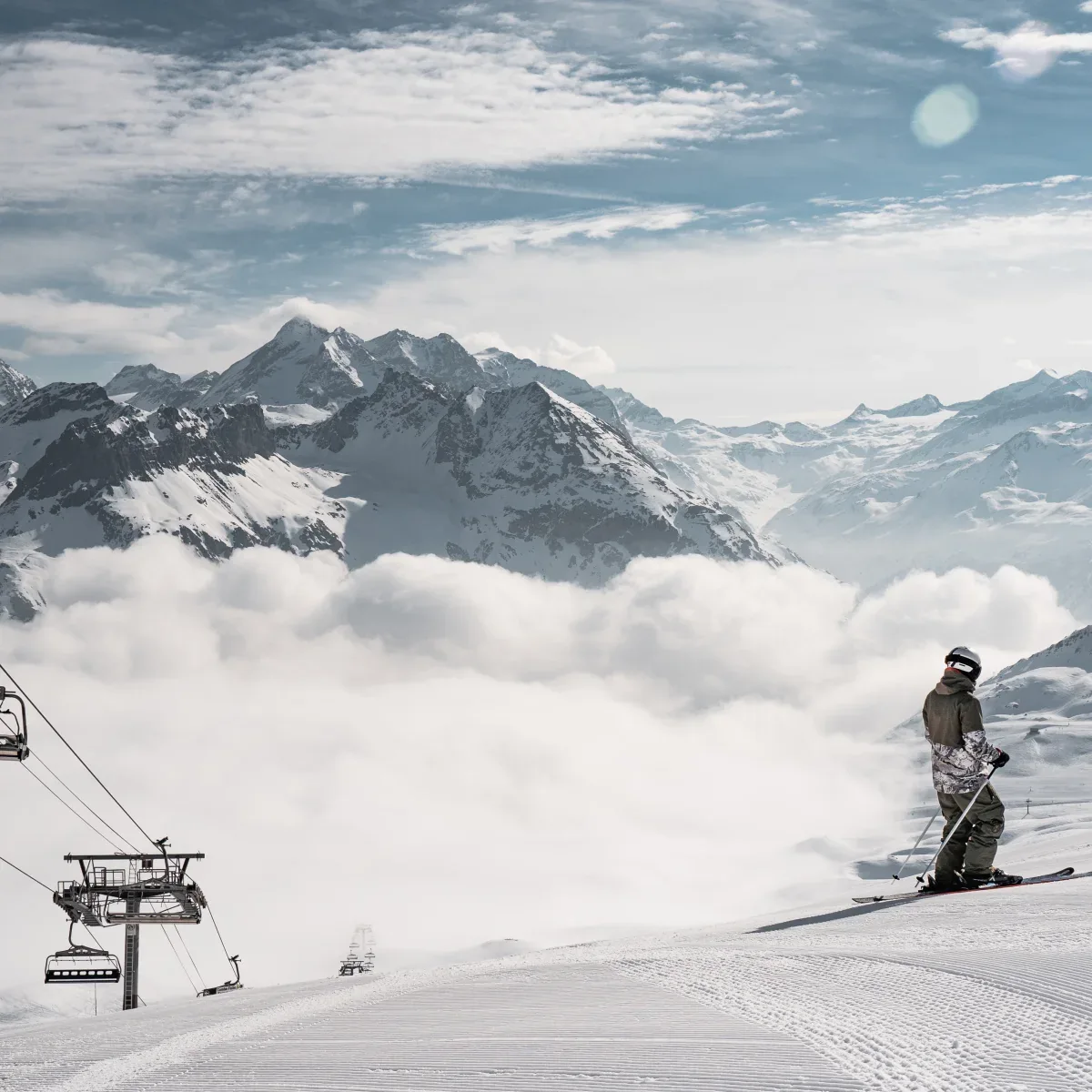 Skifahrer im Sektor Bellevarde über einer Wolkenschicht