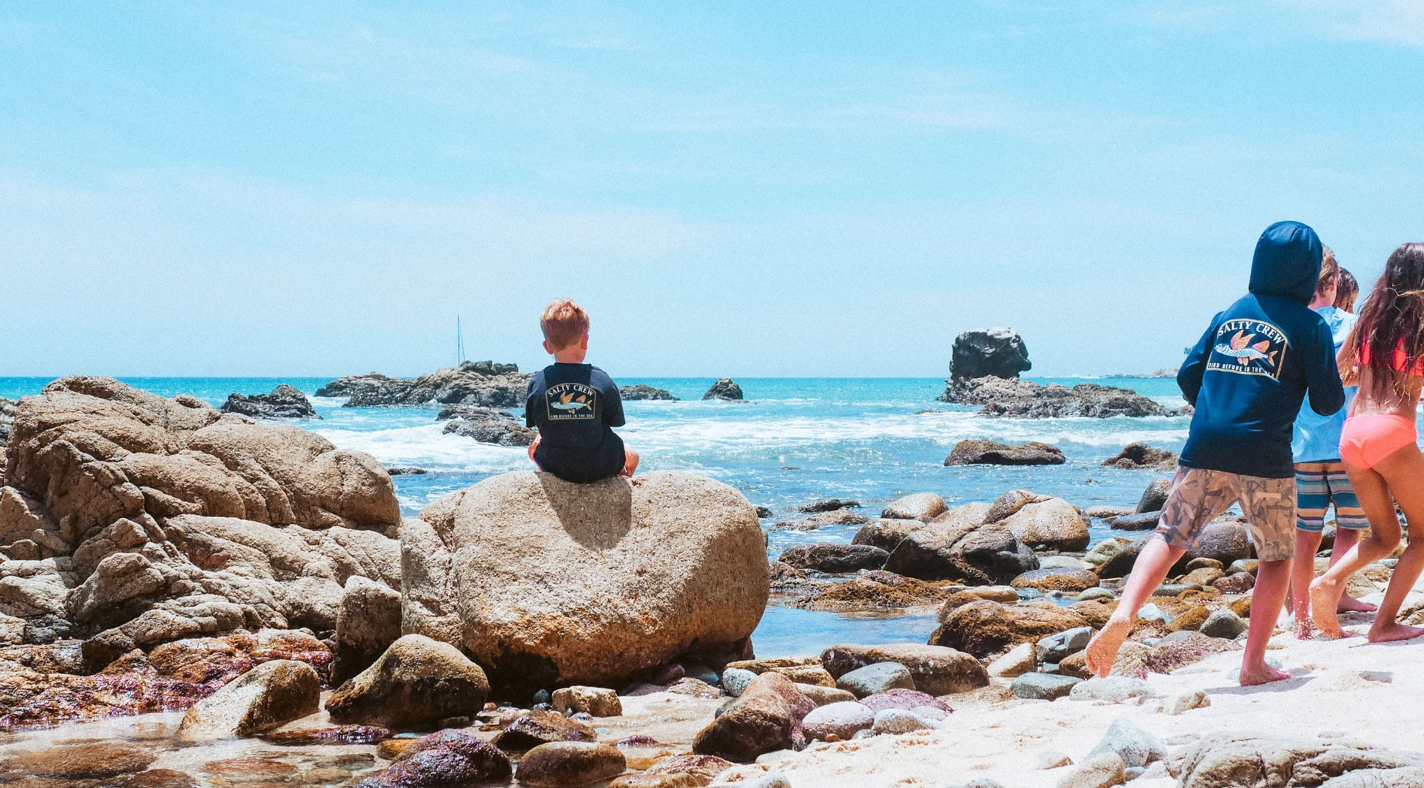 Salty Crew Kleidung und Accessoires auf verwittertem Holz am Strand