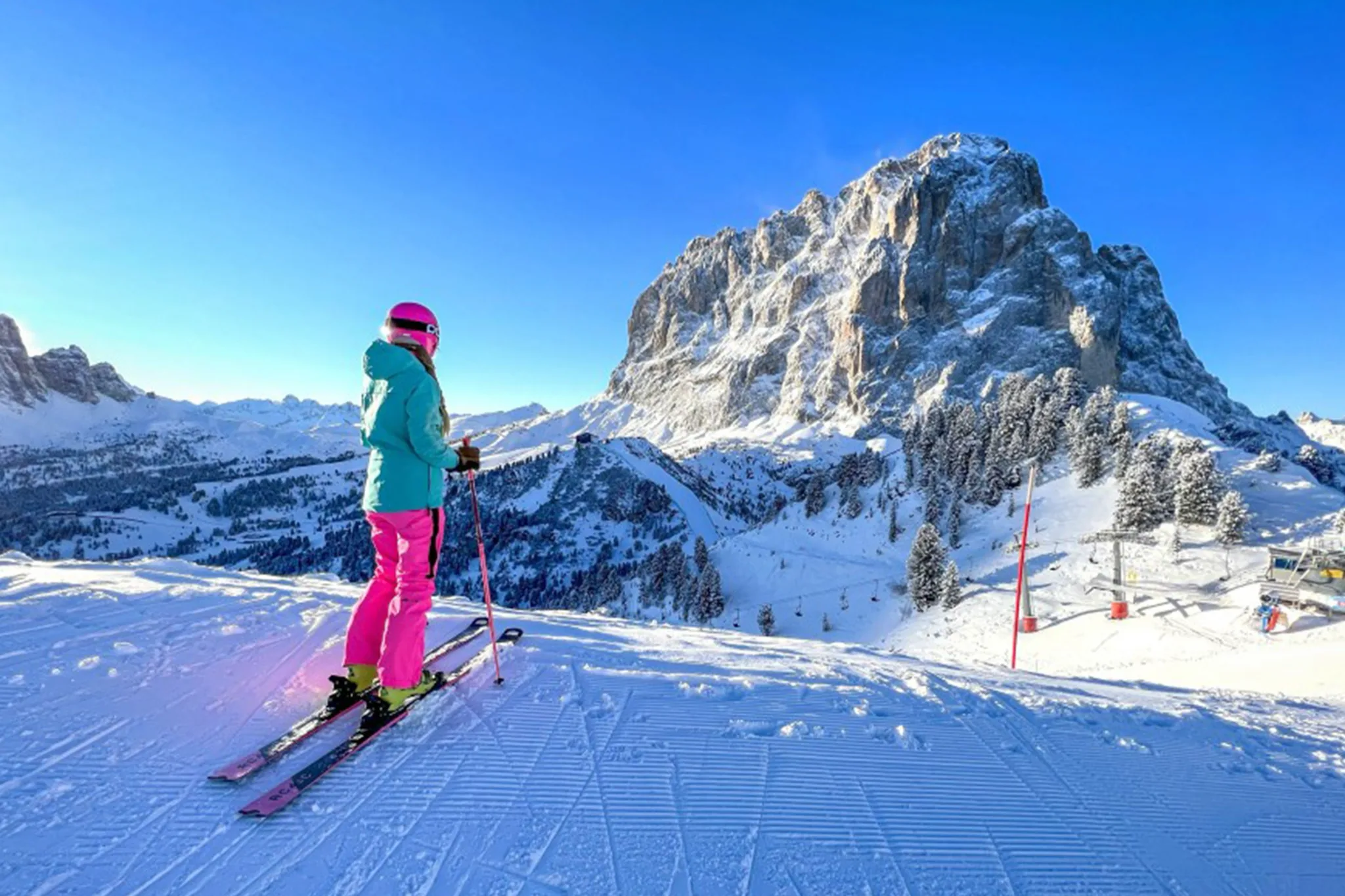 Skifahrer auf einer breiten Piste in Gröden mit Blick auf die Dolomiten