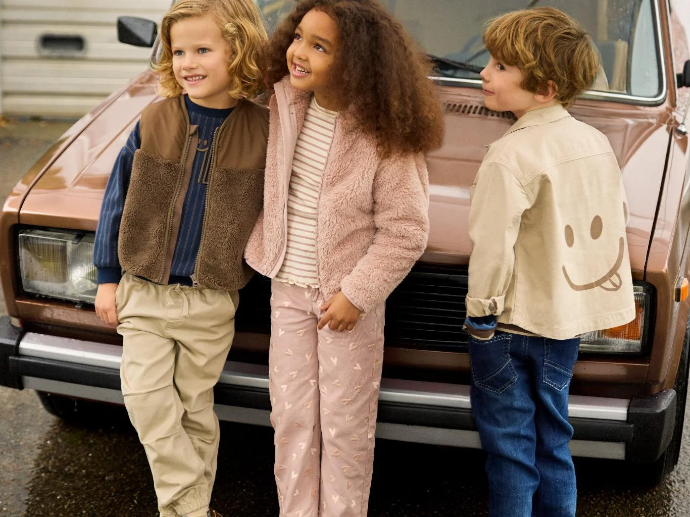 Minymo Kinderkleidung Flat Lay – Softshell-Jacke, Regenhose, Mütze und Details in kräftigen Farben