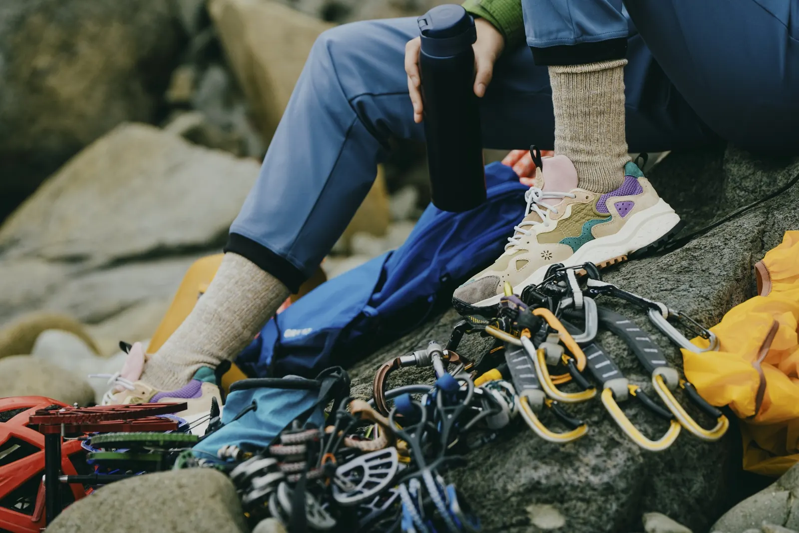 Flower-Mountain-Sneaker neben Kletterseil und Karabinern auf einem Felsen