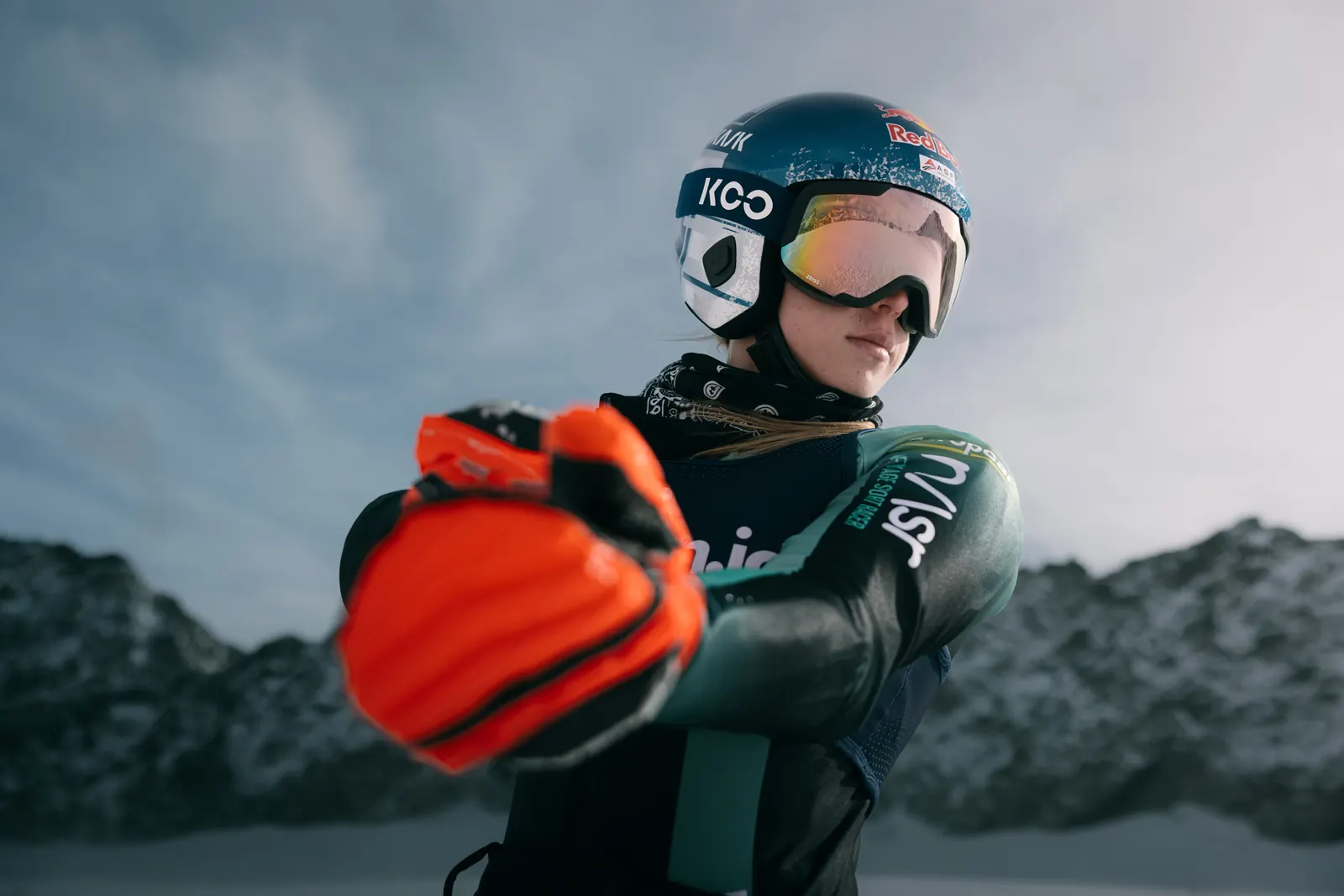 Skirennläuferin Lara Colturi mit KASK-Rennhelm und Skibrille vor verschneiten Bergen