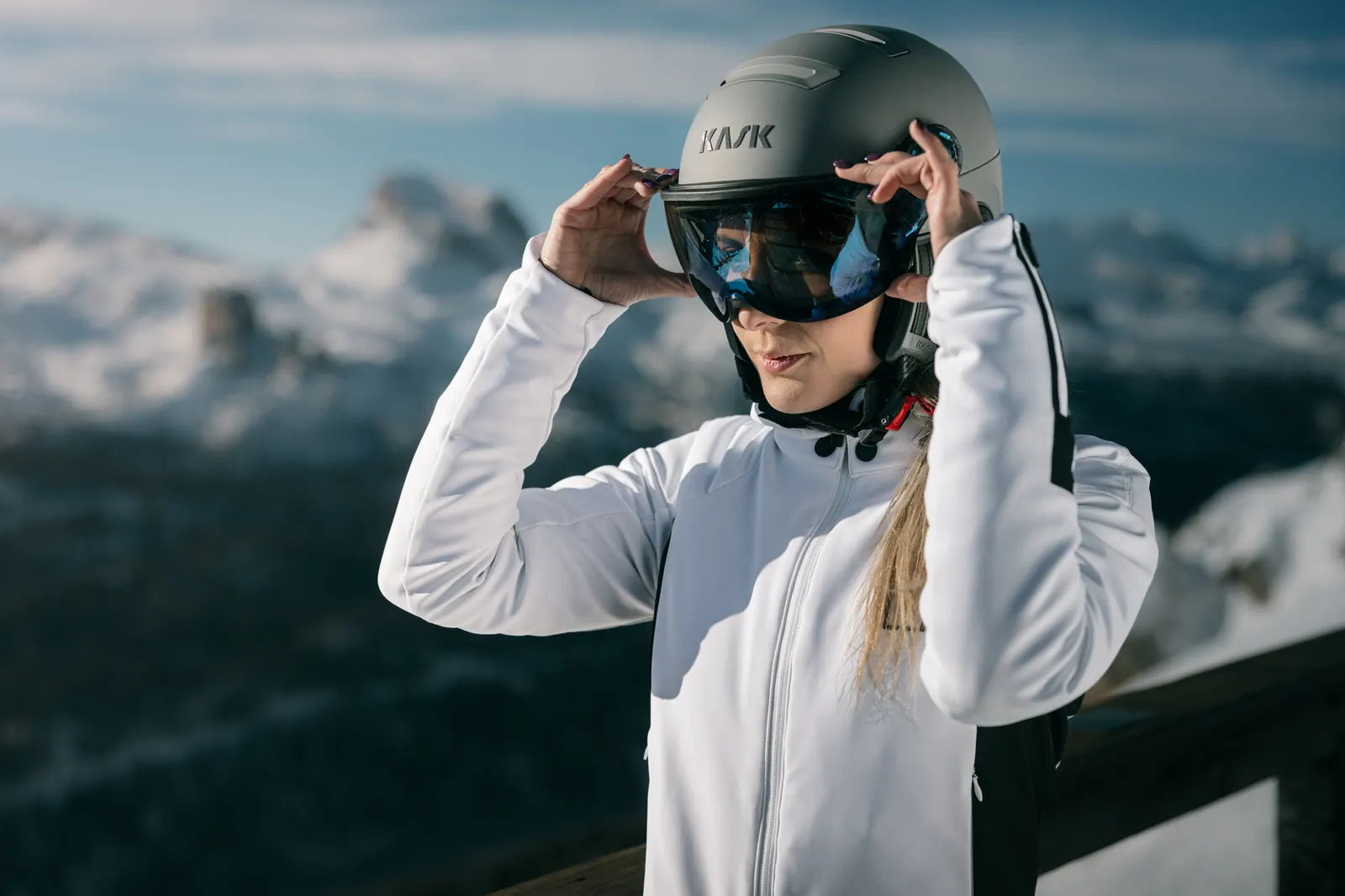 Zwei Skifahrende mit KASK-Visierhelmen auf einer Terrasse über den Dolomiten
