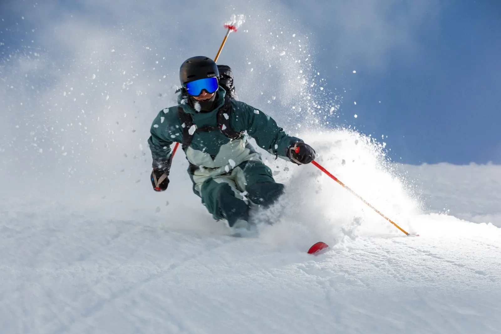 Person in Klättermusen-Skibekleidung bei einem Schwung durch Pulverschnee