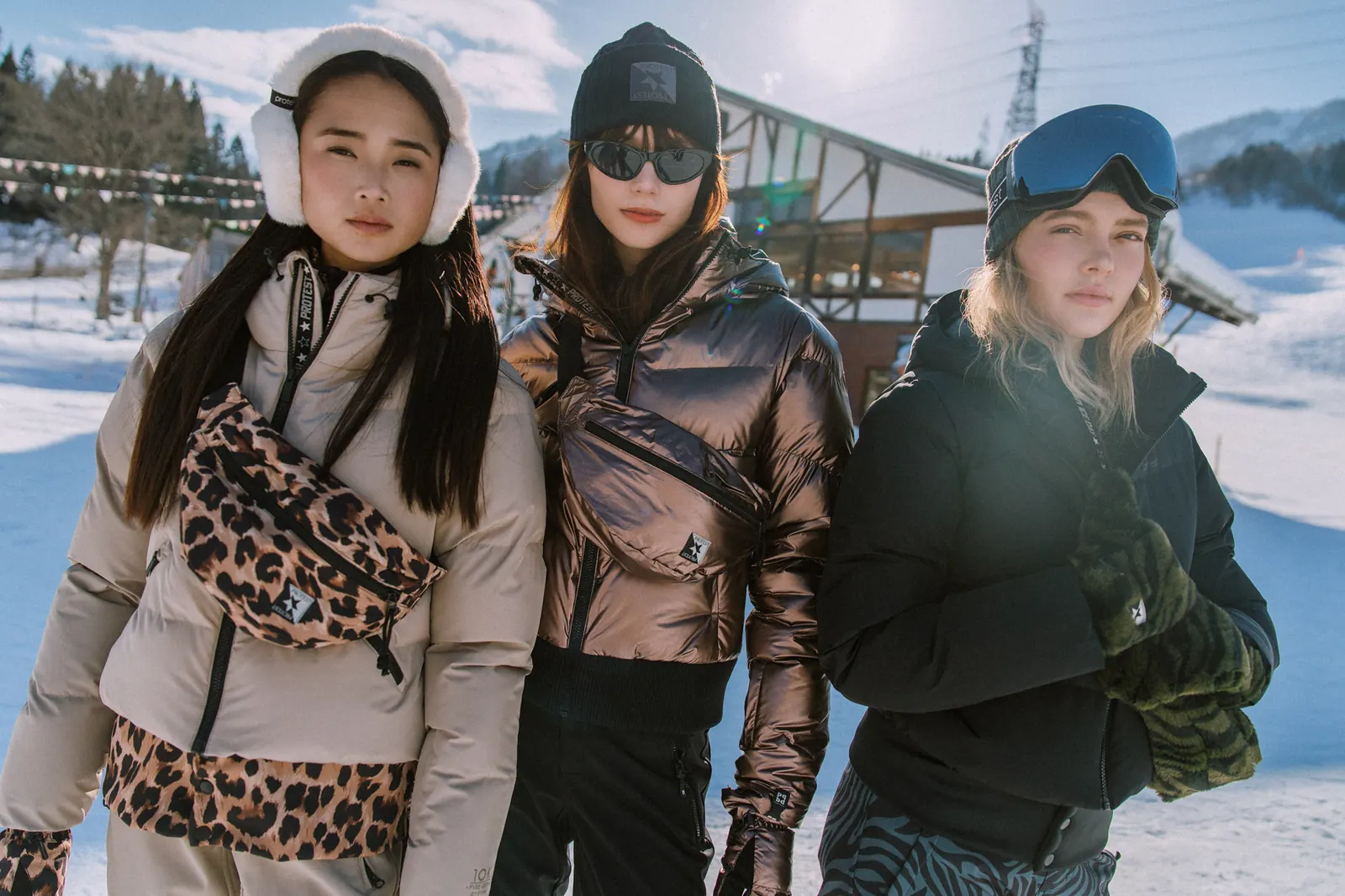 Drei Frauen in Protest-Skijacken im Schnee