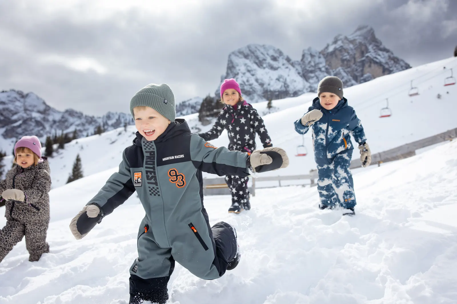 Kleinkinder in Protest-Schneeanzügen laufen durch den Schnee