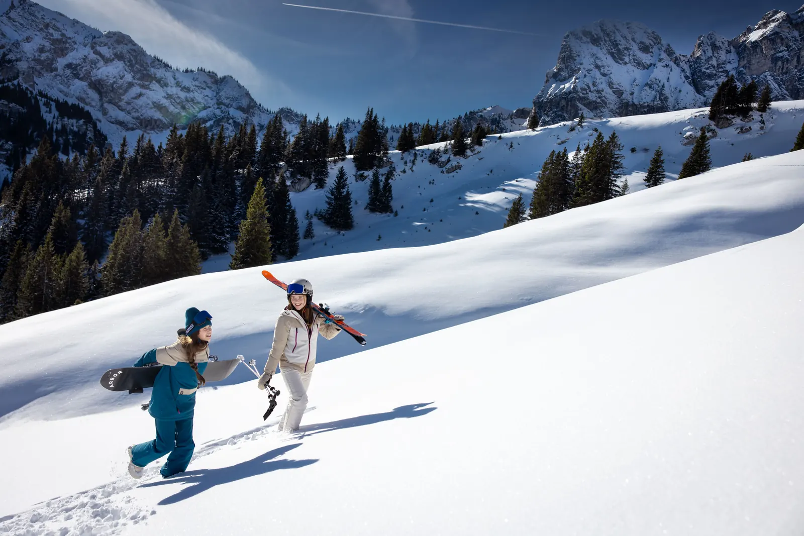 Zwei Kinder in Protest-Skibekleidung stapfen einen Schneehang hinauf