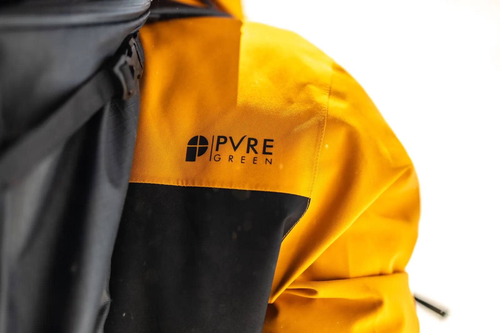Ärmel einer orange-schwarzen Protest-Jacke mit PVRE-Green-Logo