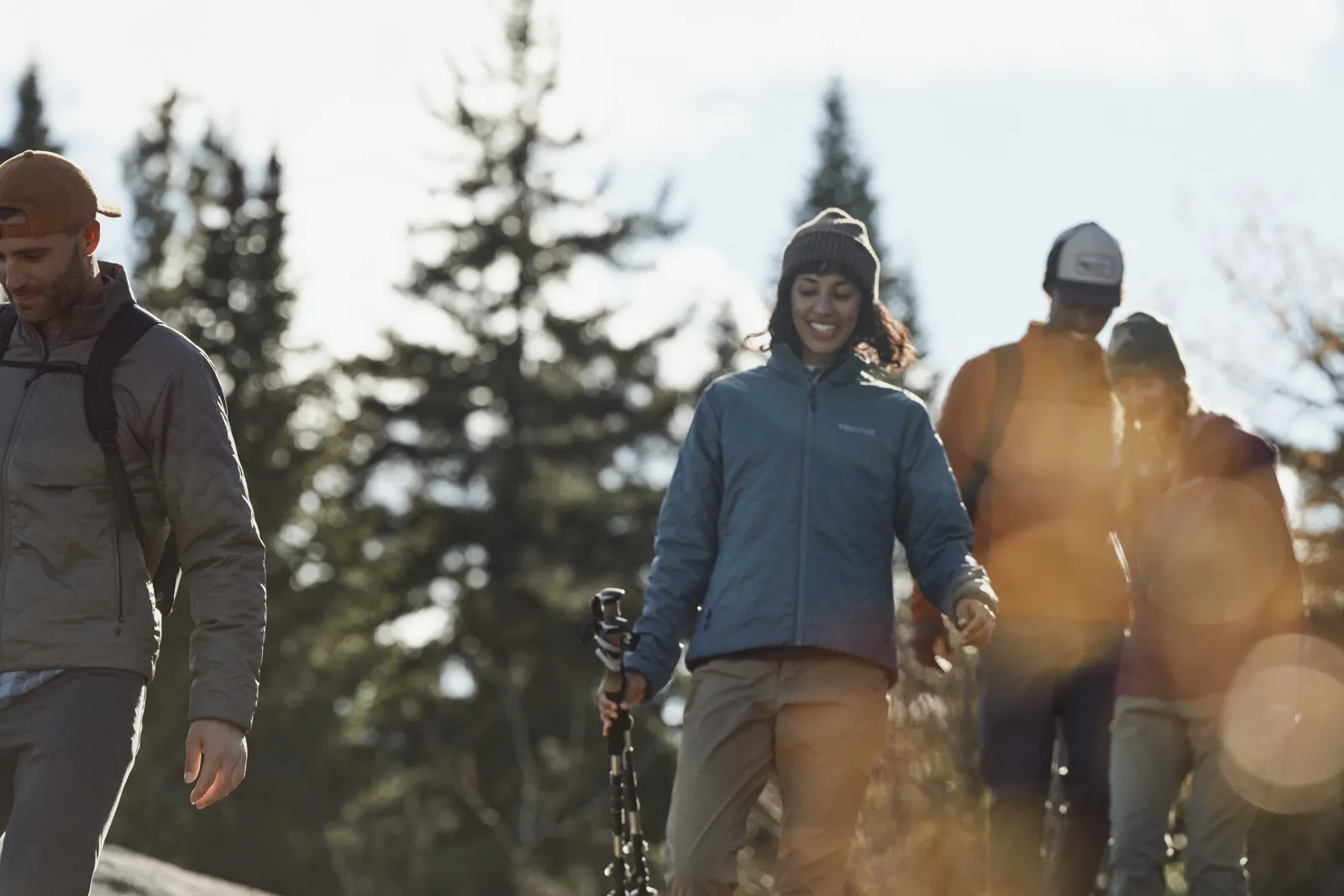 Gruppe beim Wandern im Gegenlicht, eine Person in der Marmot Revlo Hybrid Jacket