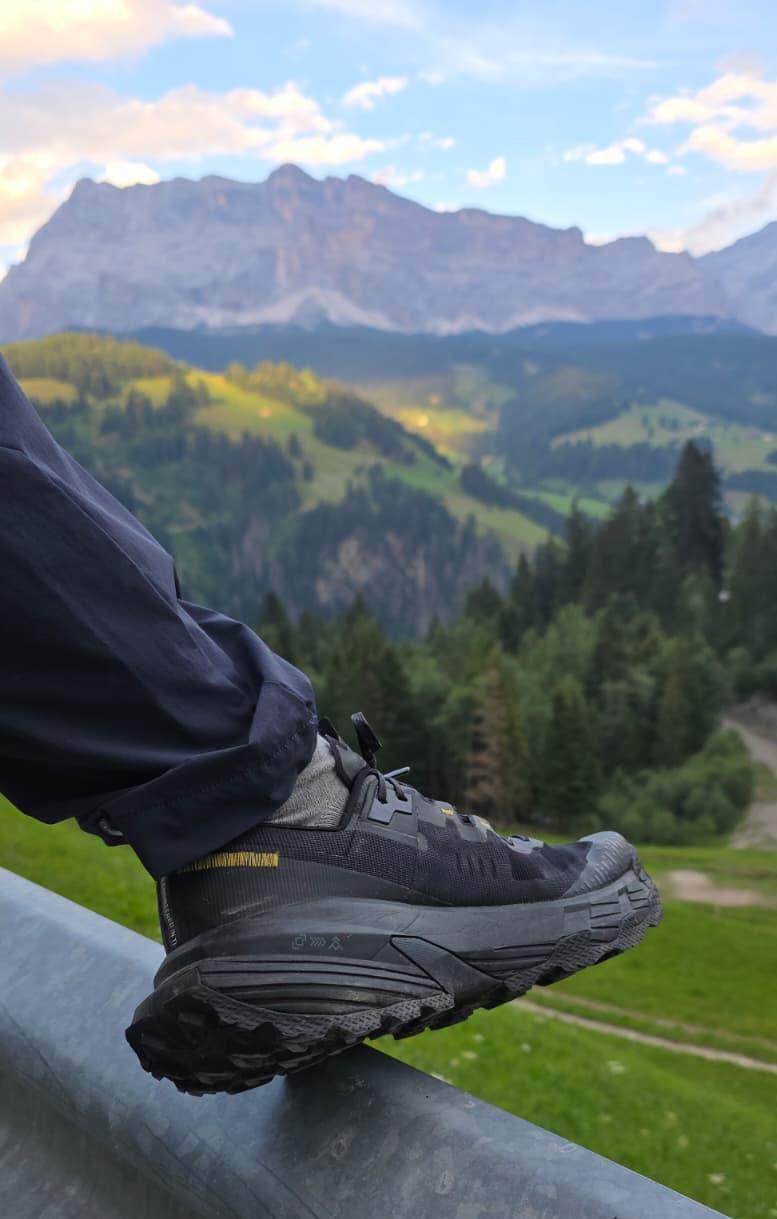 Salewa Pedroc 2 Max am Fuß eines Wanderers, im Hintergrund die Felswände der Dolomiten