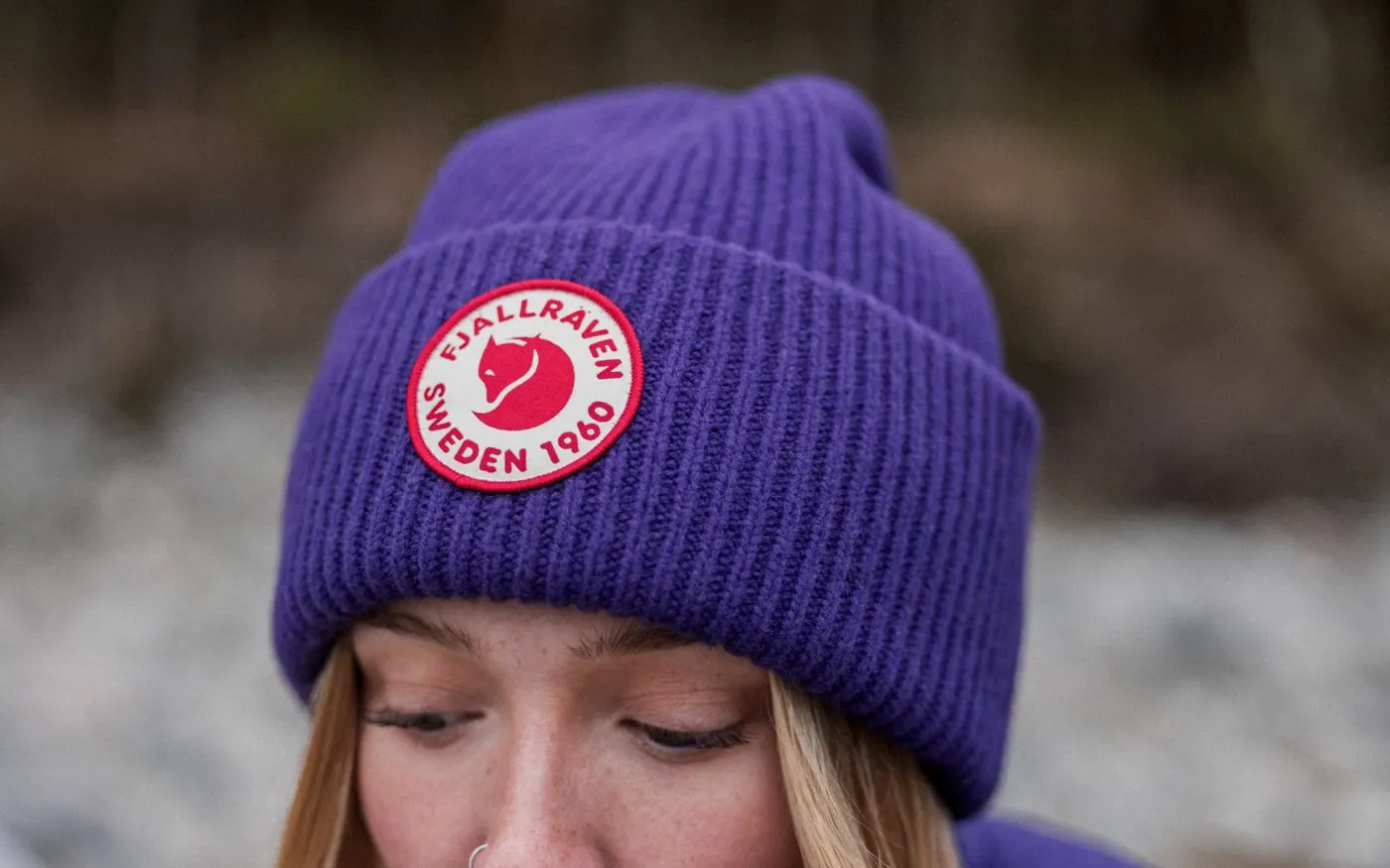 Woman wearing a purple Fjällräven knitted beanie in the forest