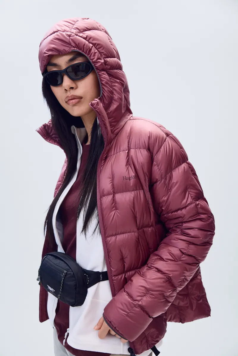 Woman in a red Haglöfs Hede Down Hood with the hood up
