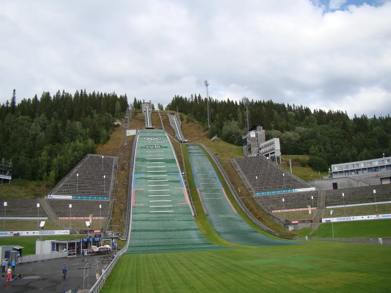 Skispringerin im Flug über der verschneiten Stadt Lillehammer