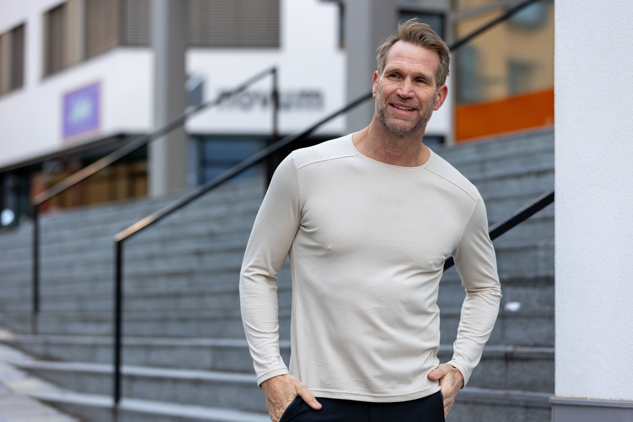 Mann trägt ein helles MAUL Sport Merino-Longsleeve als erste Lage im urbanen Umfeld